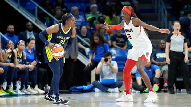 Wings guard Arike Ogunbowale tries to dribble past Atlanta's Rhyne Howard.